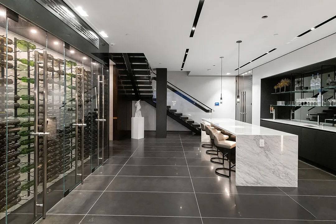 Glass wine wall, open stair and a marble waterfall island in the Hollywood residence